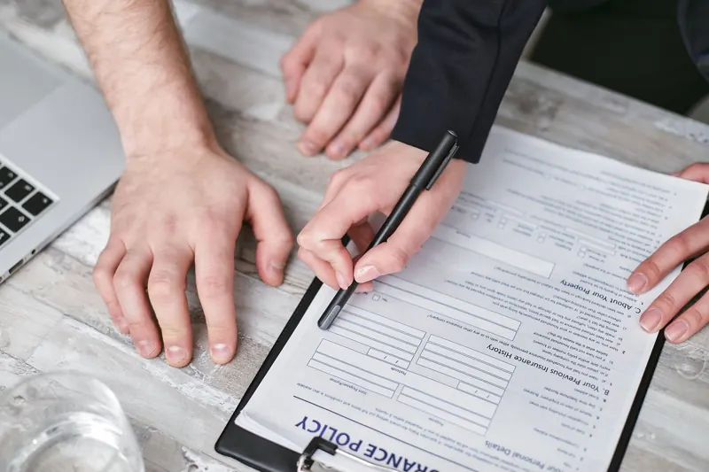 Two people review and sign a home insurance policy