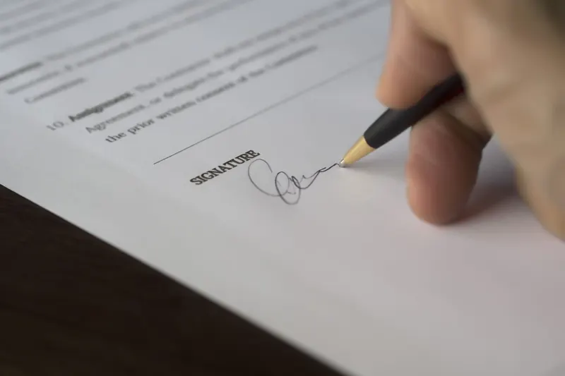 A customer signs an agreement with a pen